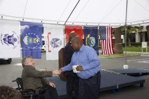 OCTA Chairman Greg Winterbottom, left, salutes Michael Jackson, a field administrator in OCTA’s Community Transportation Services Department and a retired Marine